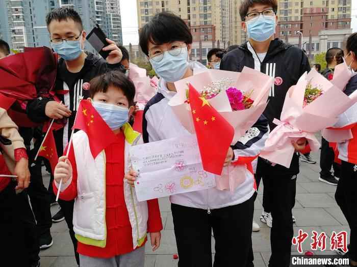 图为3月21日张静静跟随医疗队从黄冈返程时,手里拿着当地小朋友送给她的一幅画。山东大学齐鲁医院供图 山东援鄂护师张静静去世 山东卫健委:沉痛哀悼
